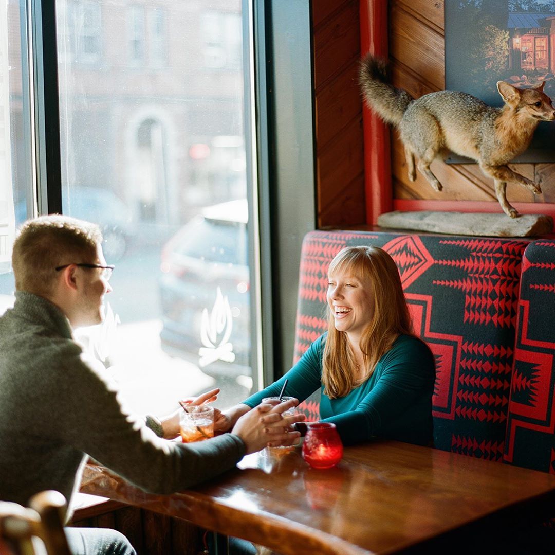 Couple holding hands inside a booth at Camp Bar